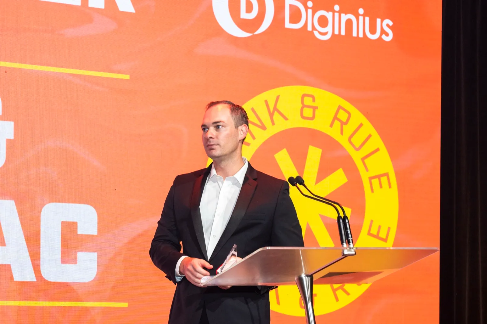 Regan McGregor presenting on stage at the APAC Search Awards