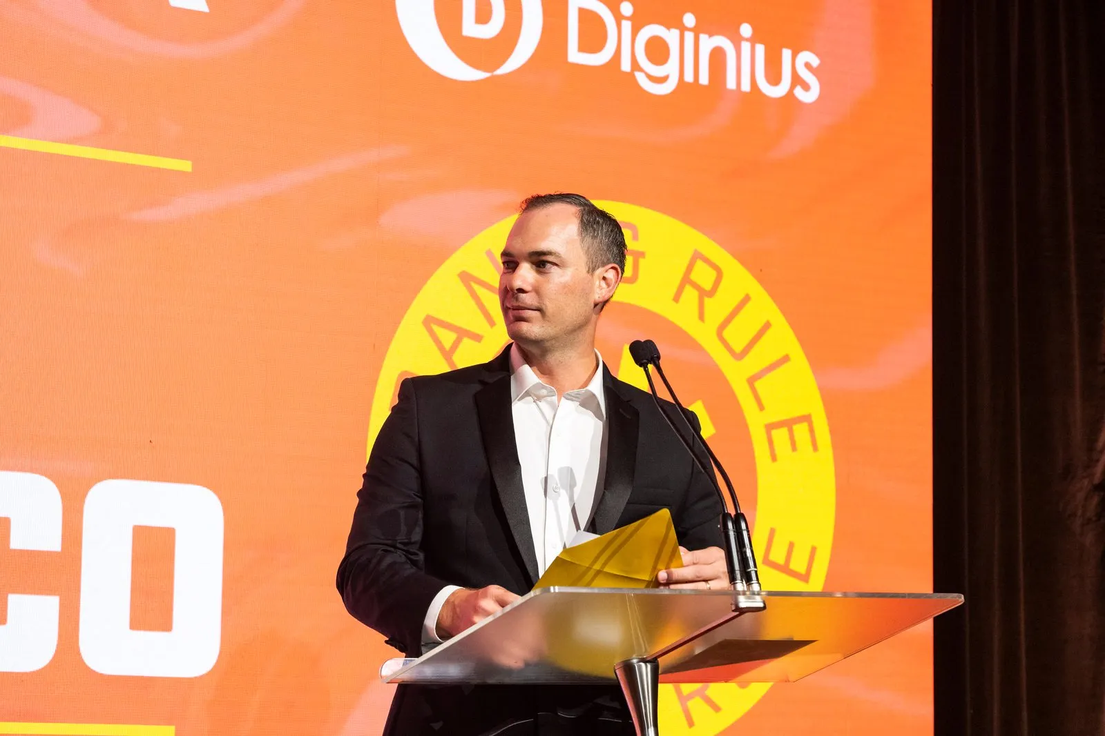 Regan McGregor presenting on stage at the APAC Search Awards